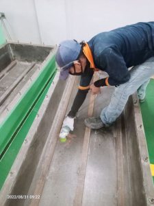 Proses Grinding permukaan bak baja sebelum pelapisan fiberglass.
