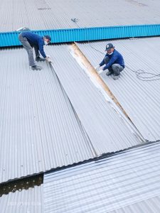 Pembongkaran atap zincalume untuk pemasangan atap penerang fiberglass, supaya hemat biaya listrik sepanjang tahun.