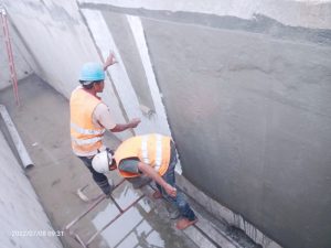 Proses pelapisan fiberglass untuk dinding beton. 